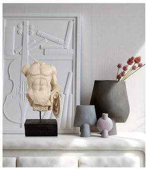 Decorative items including a marble sculpture, vases, and a lamp on a shelf with abstract wall art in the background.