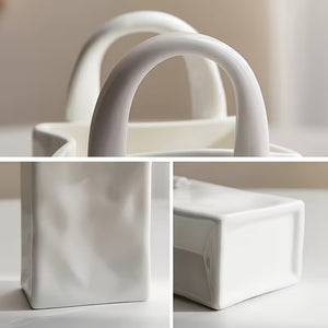 A white ceramic container with a geometric, block-like design and integrated handles, shown in a three-panel collage highlighting its form from different angles.