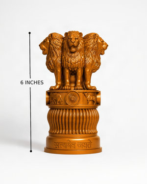An orange-brown resin statue of the Ashoka Chakra, featuring three lions and a central wheel, displayed on a fluted pedestal. A black vertical line with '6 INCHES' text indicates its height against a clean white background.