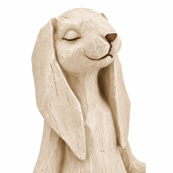 A close-up of a beige textured rabbit figurine with long floppy ears and closed eyes, shown against a plain white background.