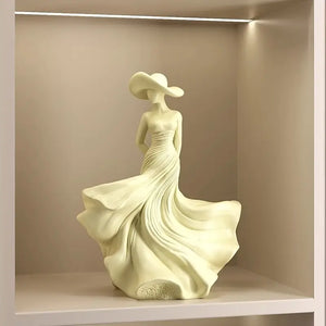 Decorative sculpture of a woman in a flowing dress on a beige shelf.