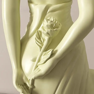 Statue of a draped figure holding a rose against a plain background Ivory Serenity Goddess Sculpture