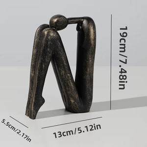 Bronze sculpture of two abstract figures intertwined with measurements on a light gray background
