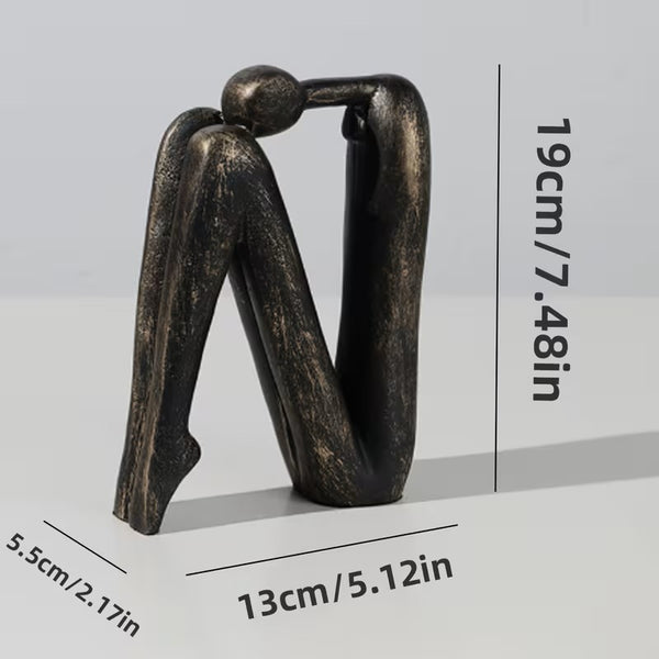 Bronze sculpture of two abstract figures intertwined with measurements on a light gray background