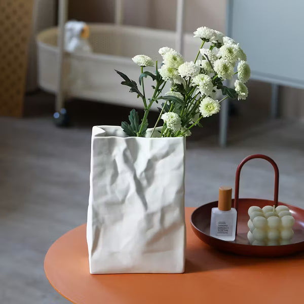 White paper bag with flowers on a table in a room setting